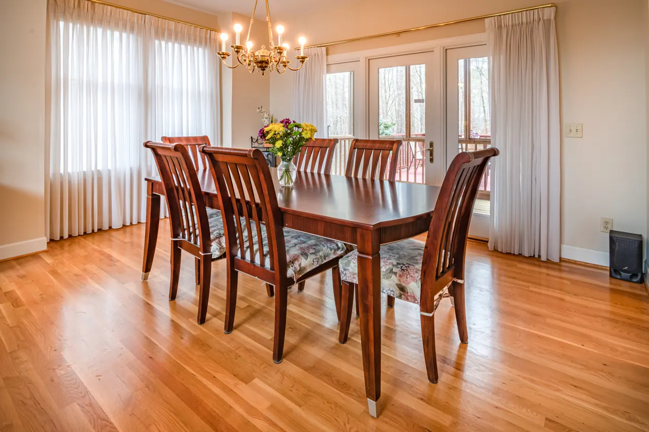 A wooden dining table and chairs in a bright room.